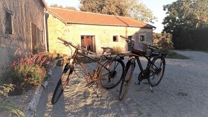 Two bicycles parked outside a building with a gravel driveway. - Gîte de Villodier - VIGEANT (LE) (VIGEANT (LE))