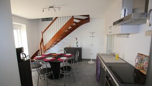 Ett modernt kök med matplats, en trappa och en inbyggd ugn.