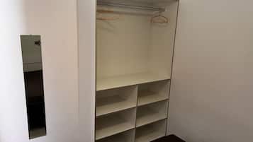 Un armario amplio con varias estanterías y una barra para colgar ropa.