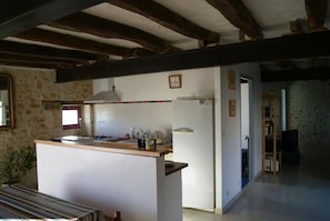 A kitchen with a central island, a stove, and a refrigerator. - Le Gîte de la Roche - ANTIGNY (ANTIGNY)