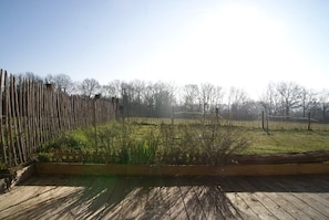 A wooden deck with a metal fence and a grassy area. - Le Gîte de la Roche - ANTIGNY (ANTIGNY)