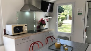 Una cocina con microondas, estufa y televisor montado sobre la encimera.
