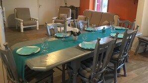 A dining area with a long table set for four, surrounded by wooden chairs. - Le Grand Gîte - LATHUS-SAINT-REMY (LATHUS-SAINT-REMY)