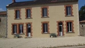 A two-story building with a symmetrical facade, featuring evenly spaced windows and doors, and a gravel driveway. - Le Grand Gîte - LATHUS-SAINT-REMY (LATHUS-SAINT-REMY)