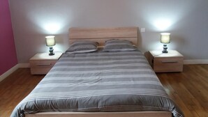 A bedroom with a bed, two bedside tables, and two wall-mounted lamps. - Le Petit Gîte - LATHUS-SAINT-REMY (LATHUS-SAINT-REMY)