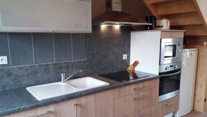 A modern kitchen with a sink, stove, oven, and cabinets. - Le Petit Gîte - LATHUS-SAINT-REMY (LATHUS-SAINT-REMY)