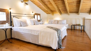 A bedroom with a wooden ceiling, a bed with white bedding, a small table, and a window. - Anerada Houses - Seaviews Above Egremni in Lefkada (Lefkada)