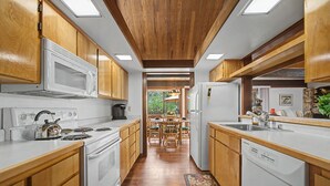 Une cuisine avec des meubles en bois, un four à micro-ondes, une cuisinière et un lave-vaisselle.