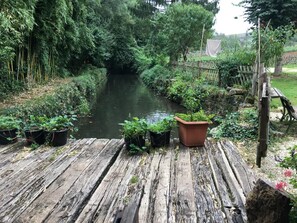 Eine Holzterrasse mit Blumentöpfen und einem Fluss.