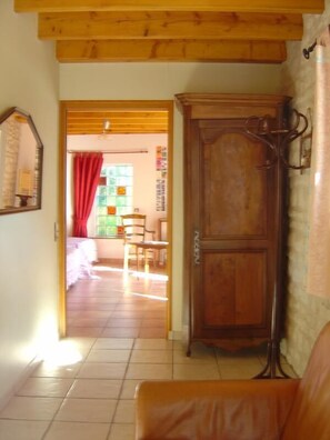 Ein Zimmer mit Holzschrank, Bett, Stuhl und Tisch.