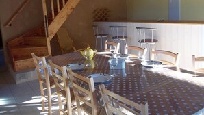 Ein Essbereich mit einer Holztreppe, einer Tischdecke mit Punkten und Stühlen.