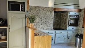 Una cocina con microondas, horno y encimera de madera.