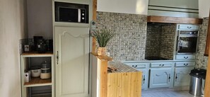 Eine Küche mit Mikrowelle, Backofen und einer Holzausstattung.