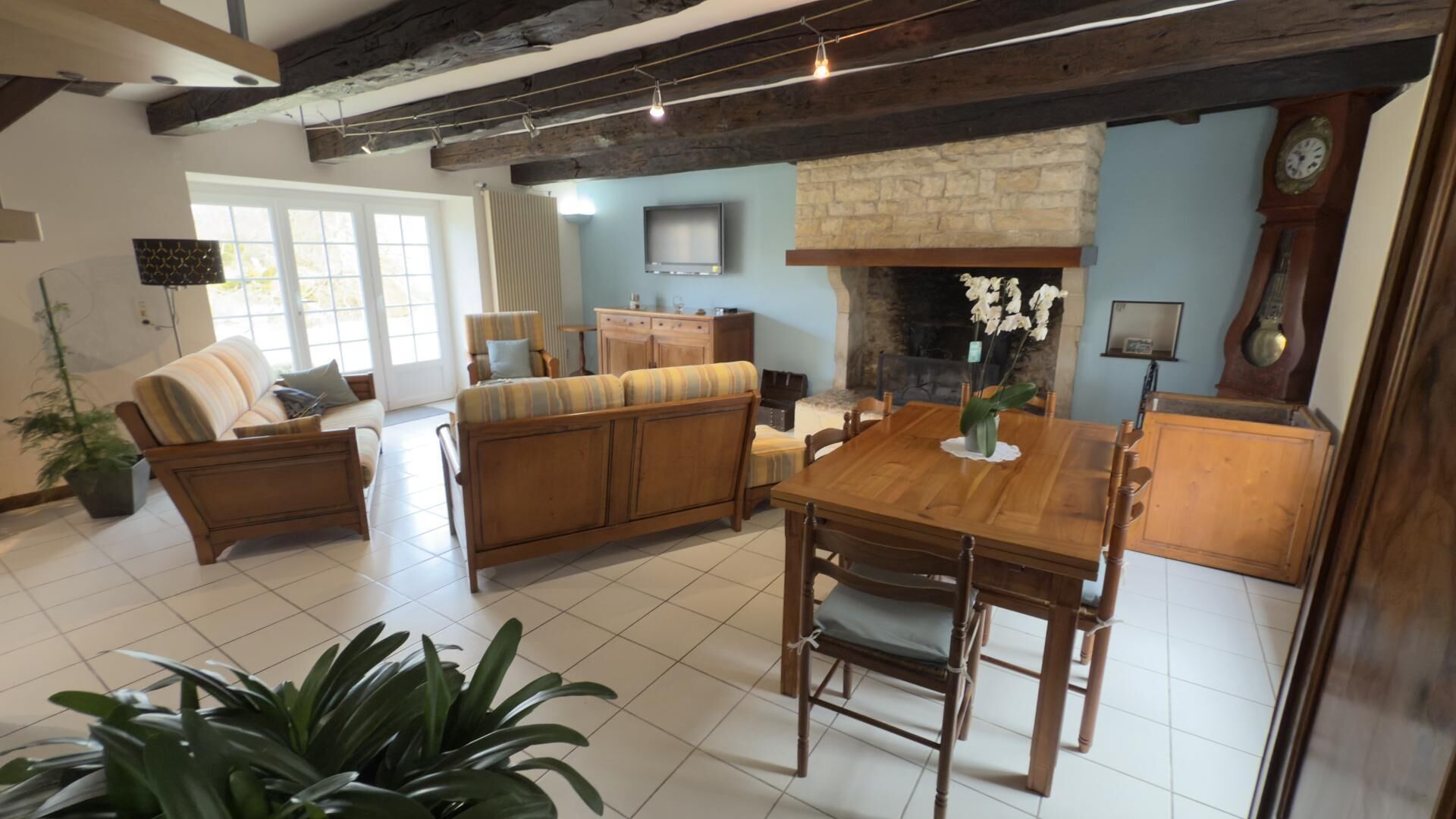Un salon avec une cheminée, des meubles en bois et un coin repas.