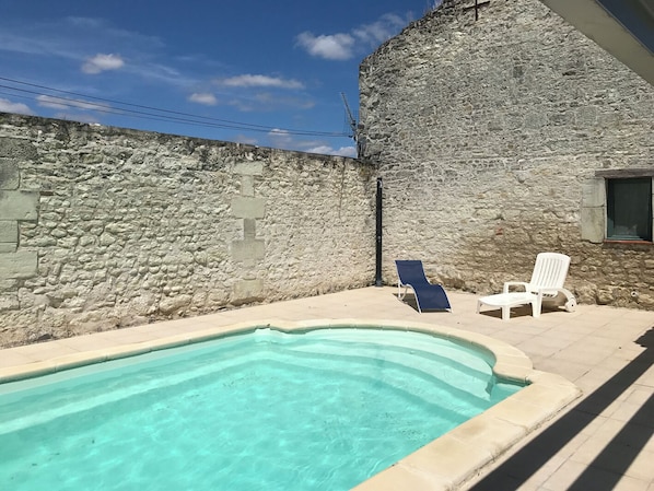 A stone building with a swimming pool and two lounge chairs. - Gîte Lamarlière - SAVIGNY-SOUS-FAYE (SAVIGNY-SOUS-FAYE)