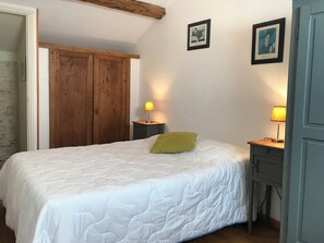 A bedroom with a bed, two bedside tables with lamps, a wooden wardrobe, and two framed pictures on the wall. - Gîte Lamarlière - SAVIGNY-SOUS-FAYE (SAVIGNY-SOUS-FAYE)