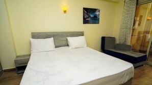 Een hotelkamer met een groot bed, een hoofdeinde, een wandlamp en een schilderij.
