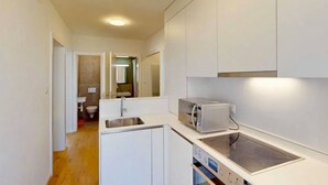 A compact kitchen with a built-in microwave, a sink, and a dishwasher.