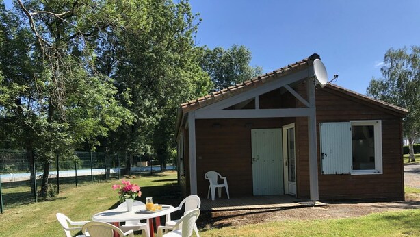 Une petite cabane en bois avec une porte, une fenêtre et une antenne parabolique.