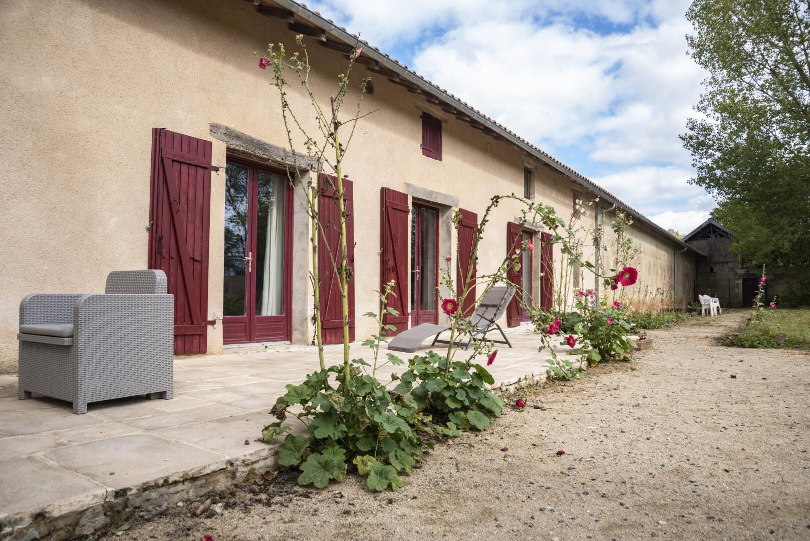 Un bâtiment doté d’un patio, d’un espace extérieur aménagé pour s’asseoir et d’un jardin fleuri.