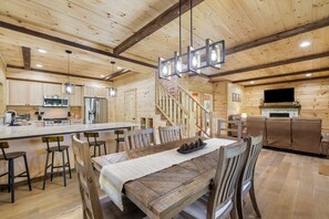 Ein Holzblockhaus-Interieur mit Essbereich, Küche und Wohnbereich.