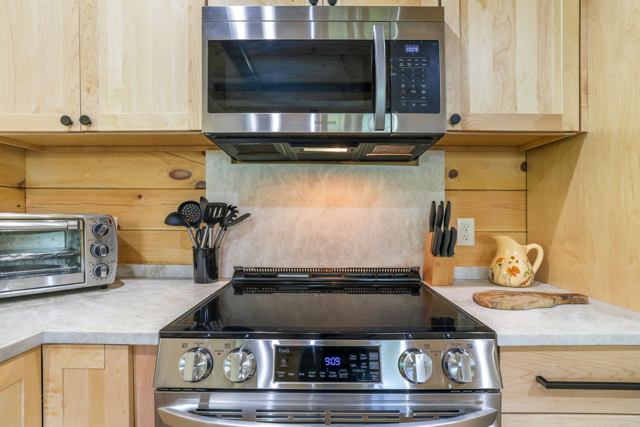 Una cocina equipada con microondas, horno tostador y estufa.