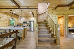 Ein Holzblock-Interieur mit Küche, Essbereich und einer Treppe.