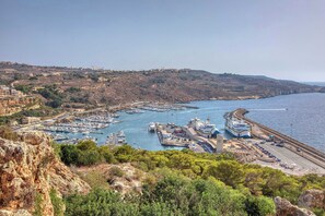 A coastal town with a marina, a ferry terminal, and a hilly landscape.