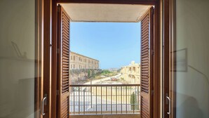 A balcony with a view of a building and a road.