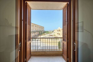 A balcony with a view of a building and a road.