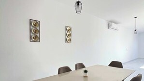 Una sala de conferencias moderna con una mesa larga, seis sillas y dos lámparas fijadas a la pared.