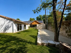 A modern house with a well-maintained lawn, a stone wall, and a wooden fence. - Clos de La Brelaisiere (CHAUVIGNY)