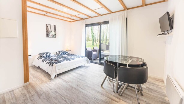 Ein Schlafzimmer mit einem Bett, einem Schreibtisch und einem Fernseher.