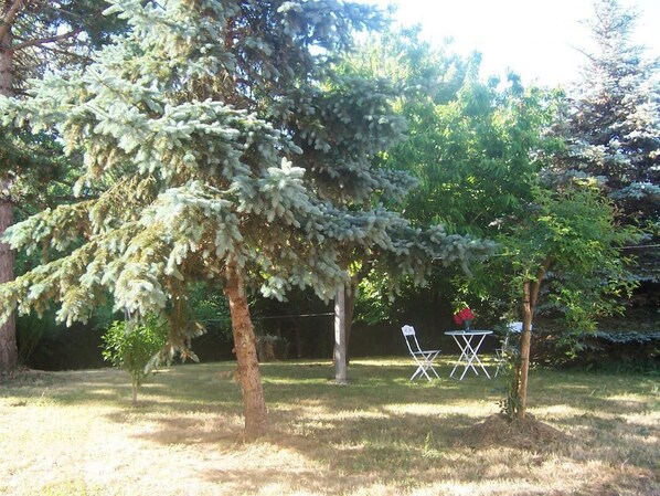 A garden with trees, a small table, and two chairs. - Gîte La Salle - VIVONNE (VIVONNE)