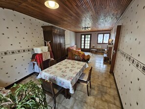 A dining area with a table set for two, a wooden cabinet, and a bench. - Gîte La Salle - VIVONNE (VIVONNE)