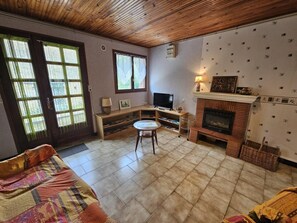 A living room with a fireplace, television, and a sofa. - Gîte La Salle - VIVONNE (VIVONNE)
