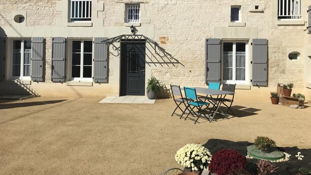 A stone building with a black door, grey shutters, and a small balcony. - The 3 Little Pigs (ROCHE-RIGAULT (LA))