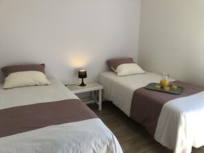 A hotel room with two beds, a nightstand with a lamp, and a tray with juice. - Chalet N° 3 - SAINT SECONDIN (SAINT SECONDIN)