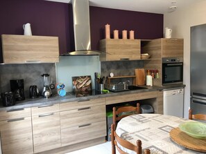 Eine moderne Küche mit Holzausstattung, einem Einbauofen und einer Kaffeemaschine.
