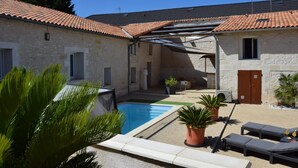 A poolside area with a stone building, outdoor seating, and a covered patio. - L'écrin - JAUNAY MARIGNY (JAUNAY MARIGNY)