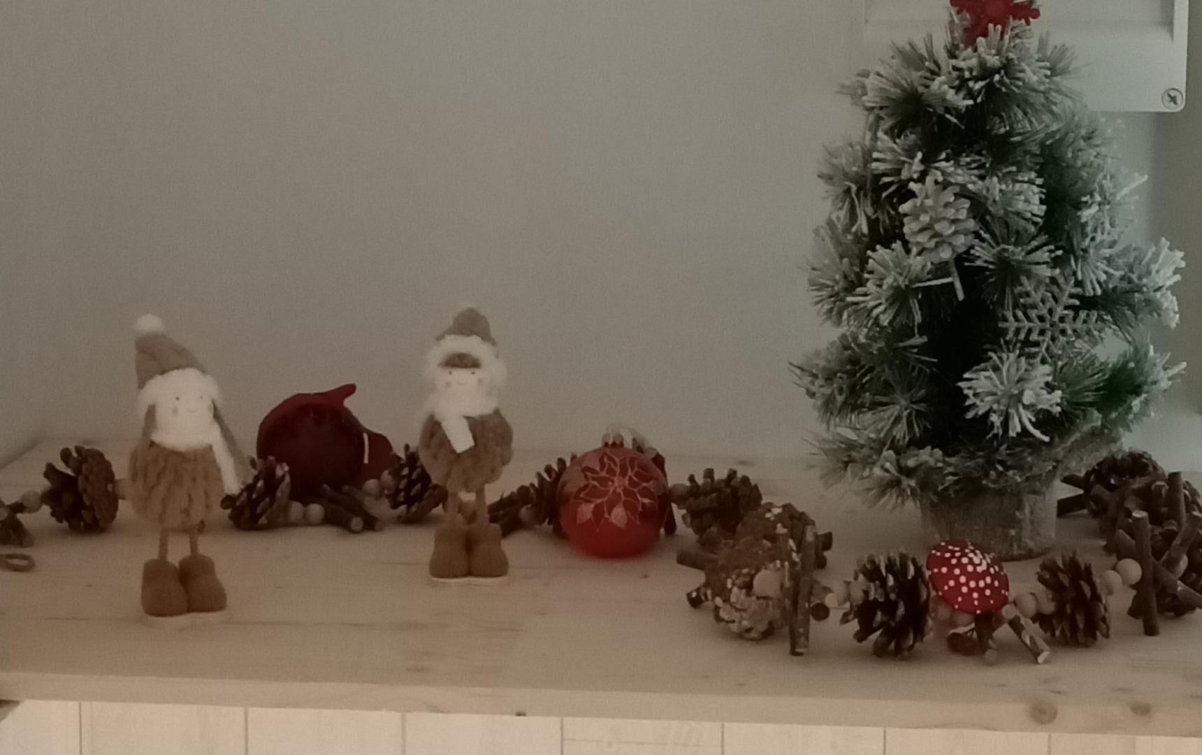 A Christmas tree with decorations and a shelf with various ornaments and figurines.