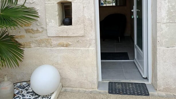 A stone building entrance with a heart-shaped decoration, a small window, and a door leading to an interior space. - L'écrin - JAUNAY MARIGNY (JAUNAY MARIGNY)