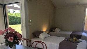 A room with two beds, a table with a vase of flowers, and a tray with glasses of juice. - Chalet N° 1 - SAINT SECONDIN (SAINT SECONDIN)