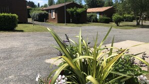 A residential area with houses, a gravel driveway, and a well-maintained lawn. - Chalet N° 1 - SAINT SECONDIN (SAINT SECONDIN)