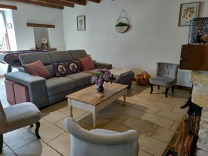 A living room with a grey sofa, a wooden coffee table with a vase, a grey armchair, and a small grey armchair. - Childhood memories - CHAUNAY (CHAUNAY)