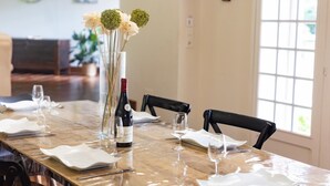 Tavola imbandita con tovaglioli bianchi, bicchieri da vino e una bottiglia di vino.
