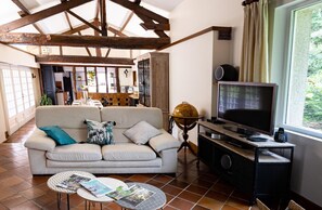 A living room with a sofa, two coffee tables, a television, and a globe. - La Cartonnerie - MIGNE AUXANCES (MIGNE AUXANCES)