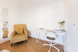 A room with a white desk, a yellow armchair, a white chair, and a mirror on the wall. - The Stylish Minimalist Lakefront (Lausanne)