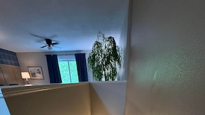 Matolla päällystetty portaikko, jossa on kaide, kattotuuletin ja seinään kiinnitetty valaisin.