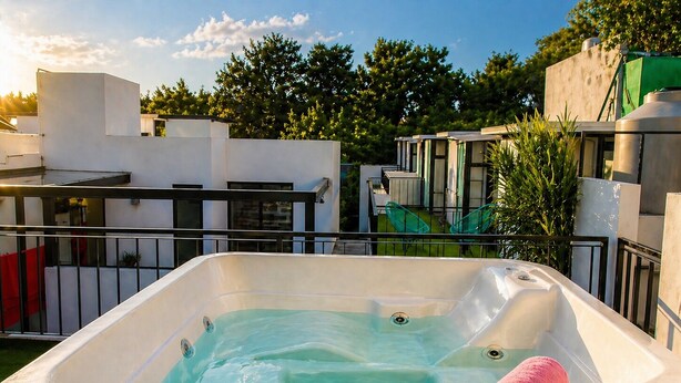 A hot tub with a pool, surrounded by a metal railing, and pink towels on the side. - Frida's Favorite Loft in Coyoacan, walk to Frida Kahlo's "Casa Azul" Museum. (Ciudad de México)